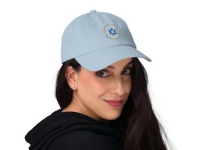 Woman wearing light blue cap with embroidered emblem