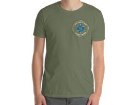 Man wearing an olive green Van Cortlandt Jewish Center logo t-shirt